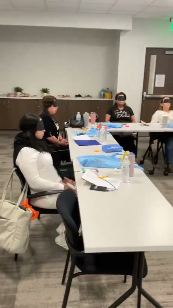 Video: Participantes con los ojos vendados durante una dinámica en sus mesas.